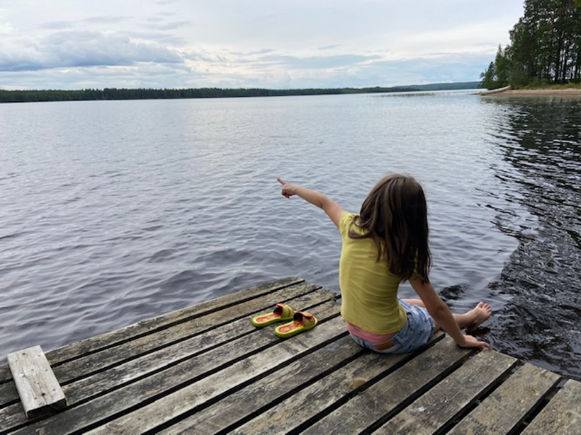 Kuva lapsesta laiturilla.