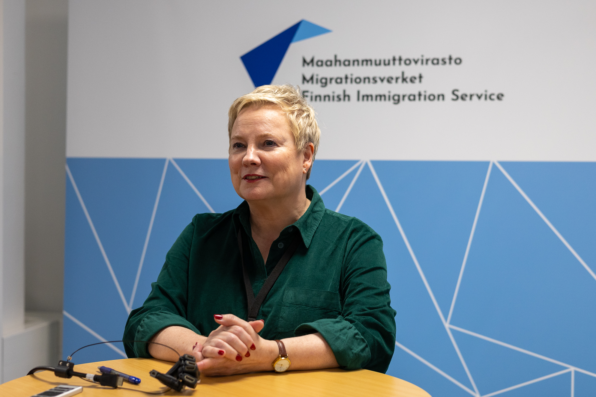 Henkilö istuu pöydän ääressä ja katsoo eteenpäin.